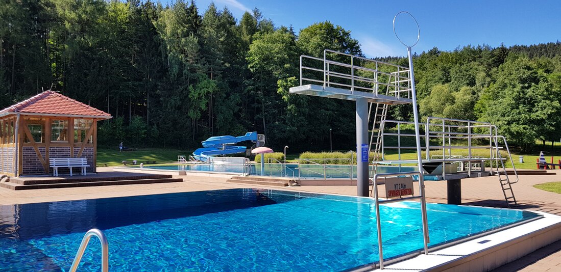 Jugendliche springen vom Sprungturm ins Wasser