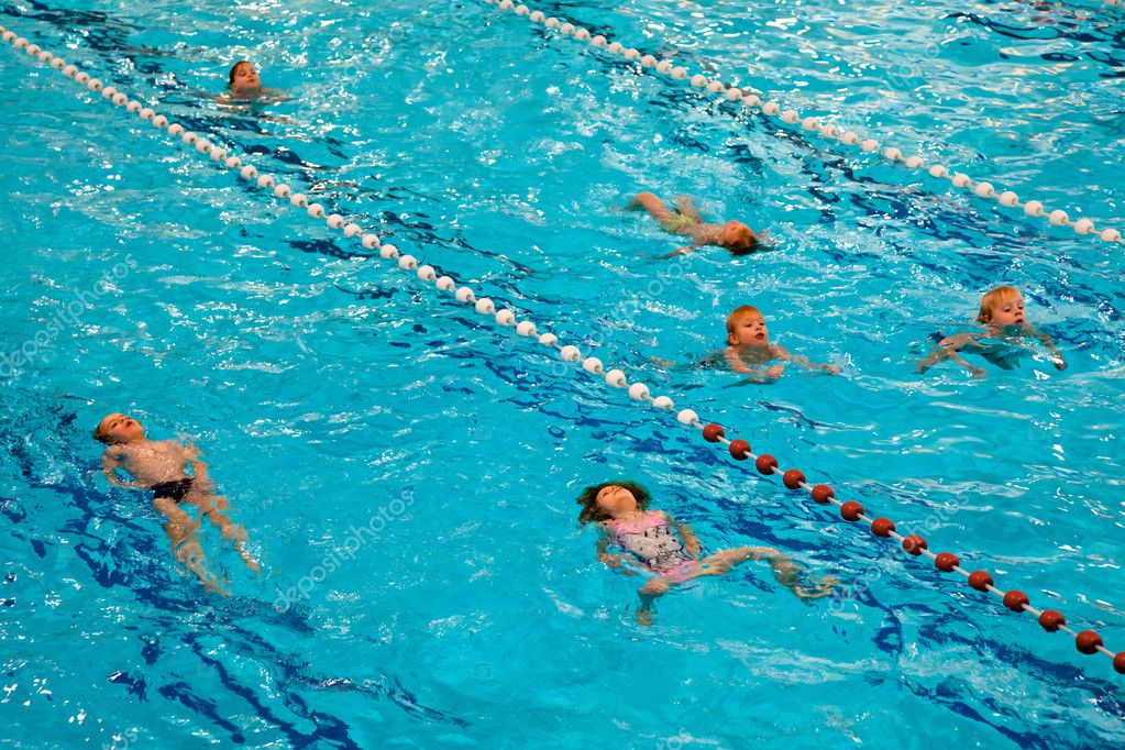 Kinder beim Schwimmunterricht mit Trainer im Freibad